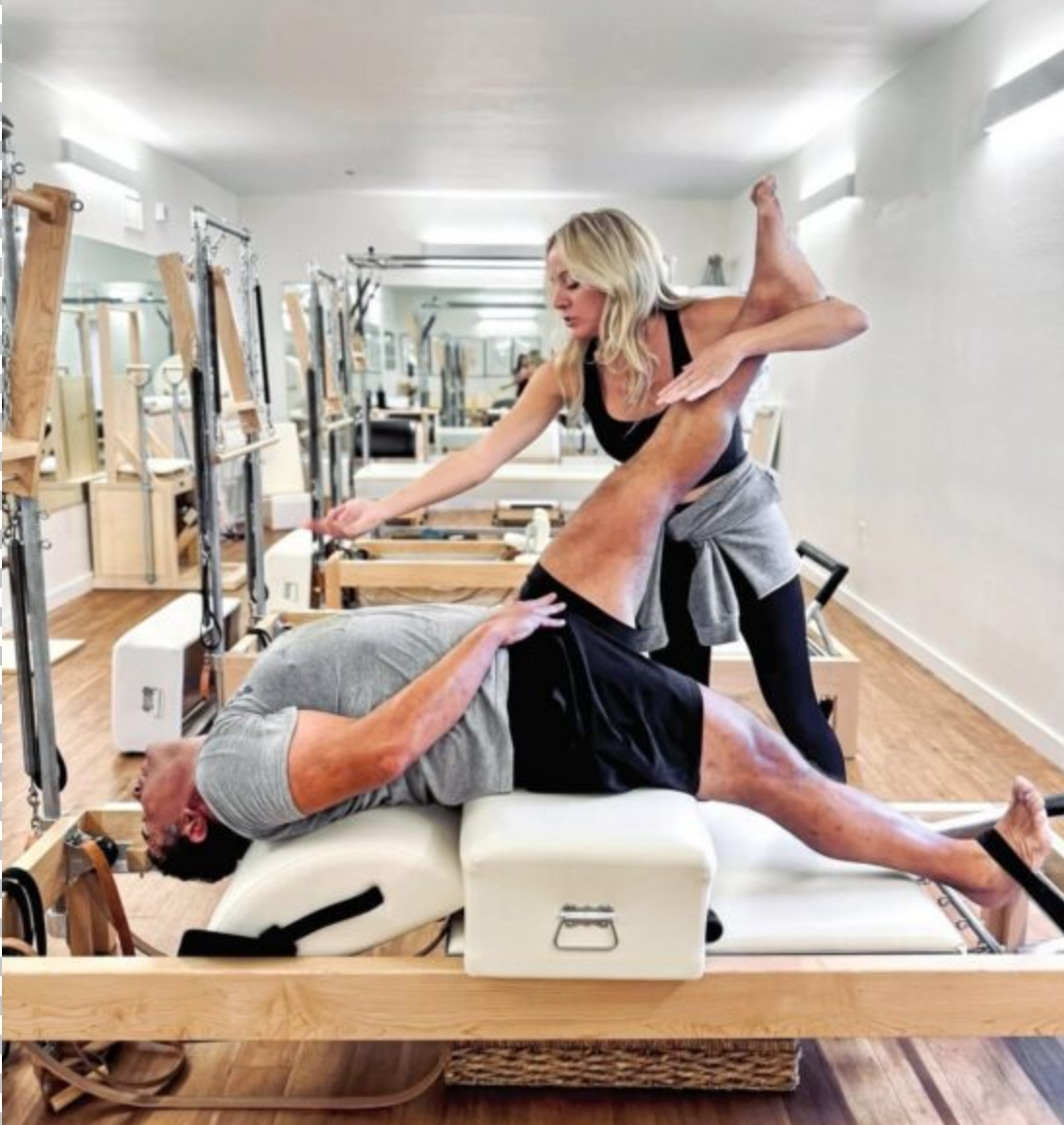 Instructor coaching a man through a private Pilates session at Sharp Pilates in Austin, TX